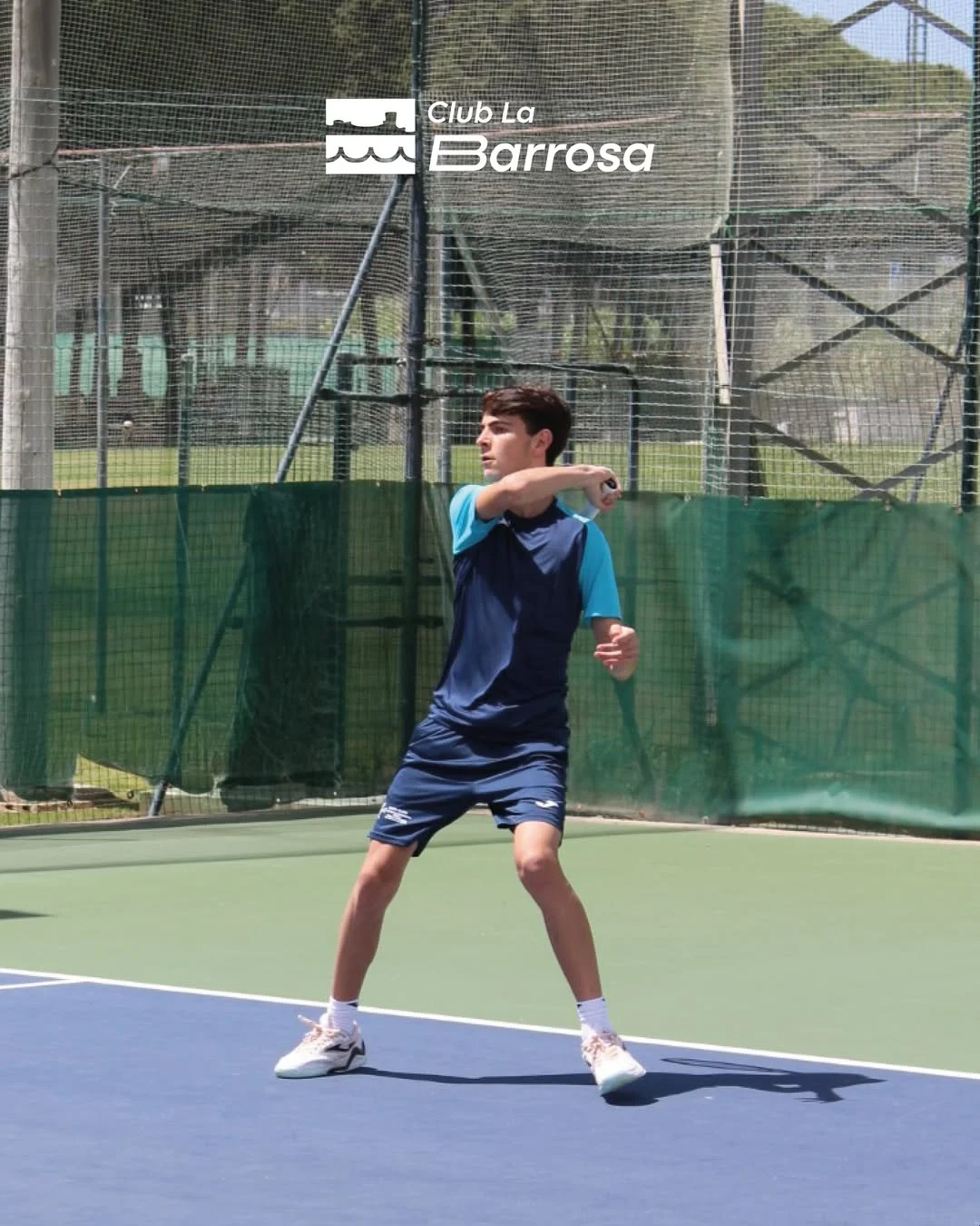 Jugador de tenis del Club La Barrosa ejecutando un golpe de derecha en pista