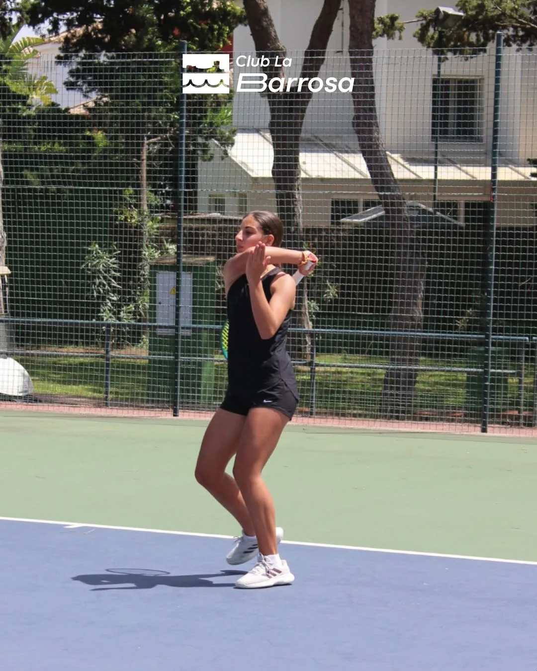 Jugadora de tenis del Club La Barrosa golpeando la bola durante el torneo