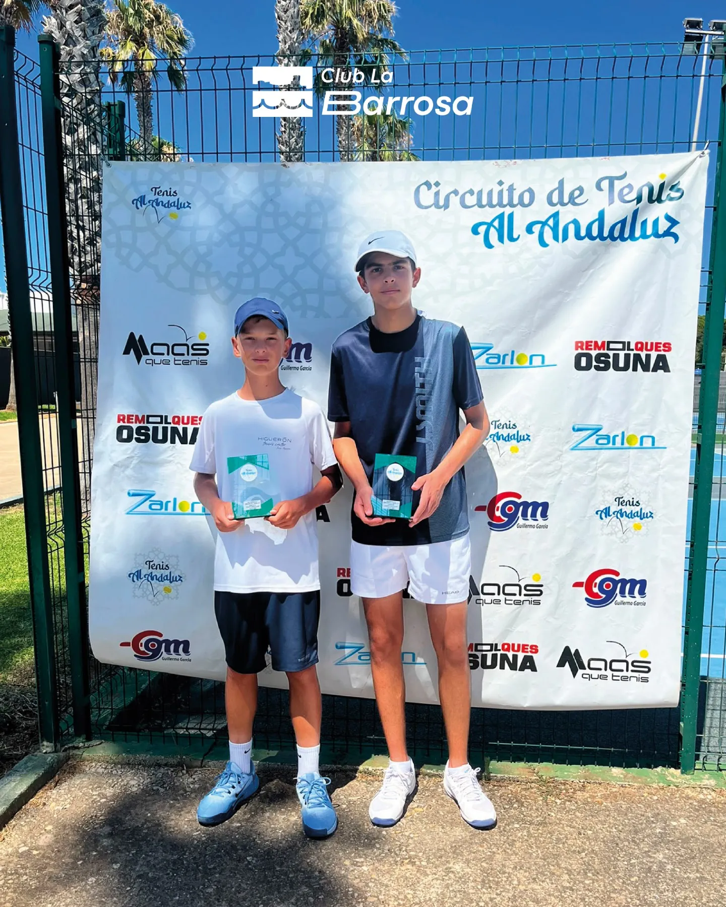 Campeón y finalista infantil masculino con sus trofeos ante el photocall del circuito