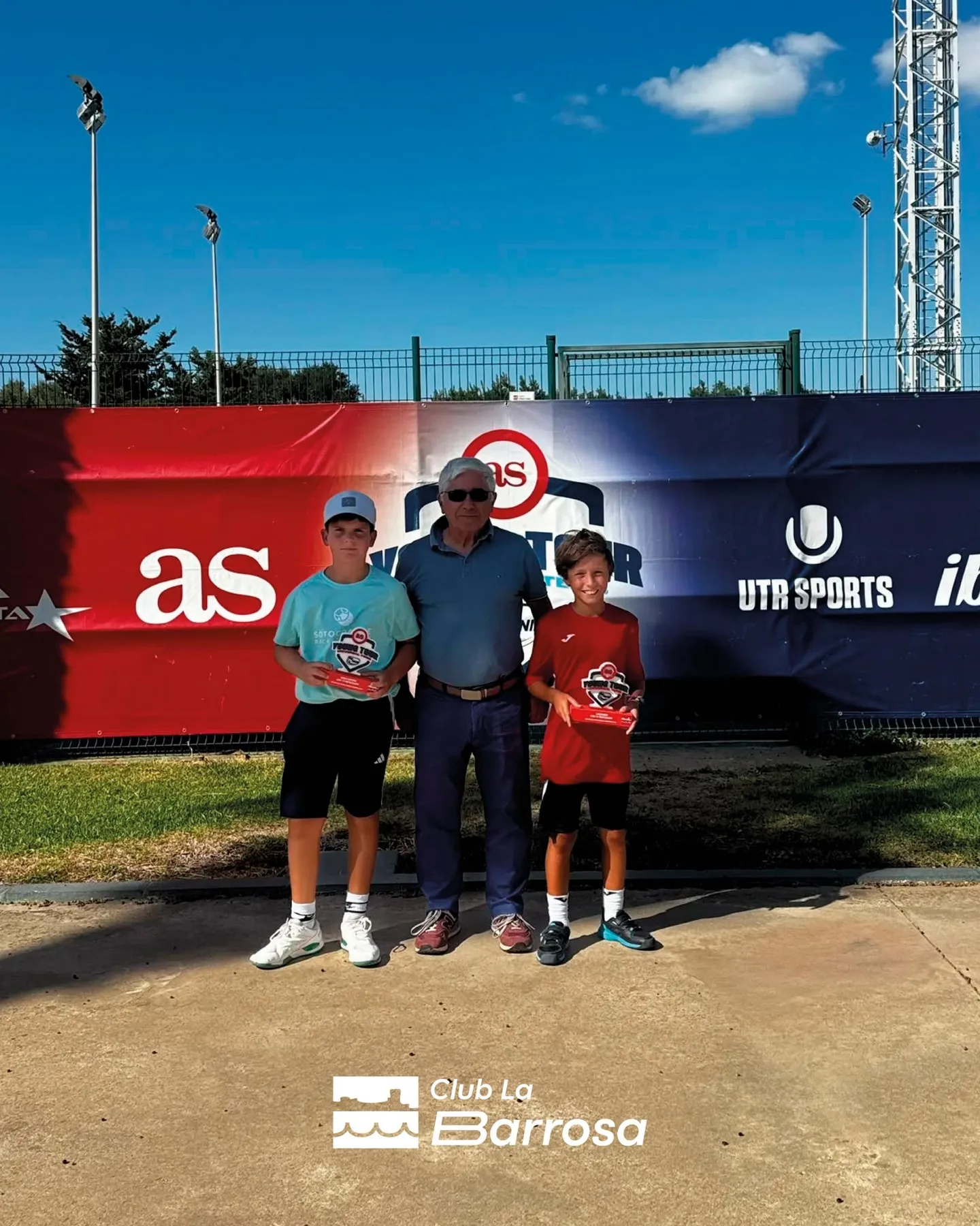 Campeonas sub-12 posando con sus trofeos junto al representante del club